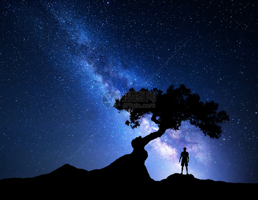 蓝色银河树人银河系夜空中星星,老树个独自站山上的人的轮廓蓝色的银河,光人旅行背景树下个人的剪图片
