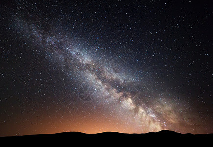 令人大为惊奇的丘陵夜间景观与惊人的银河黄光山上夏天小山的星空美丽的星系的宇宙太空背景背景