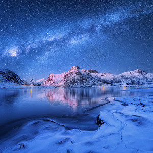 挪威洛福腾群岛的冬天,冰封的海岸上的银河雪覆盖着山脉北极景观蓝色的星空,水,冰,雪岩,银河美丽的背景图片