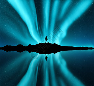 极光蓝北极光站山上的人的轮廓极光快乐的人蓝天上星星北极光夜景与北极光,海洋,天空反射水中旅行背景