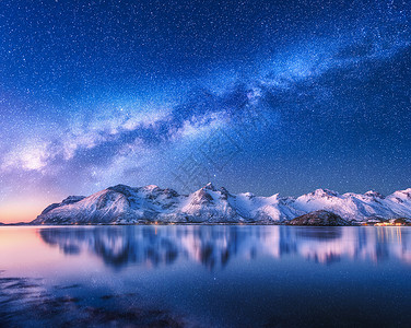比利茨基盖满雪上明亮的银河覆盖着挪威冬天的山脉大海风景雪岩,星空,倒影水中,峡湾洛芬岛美丽的银河背景