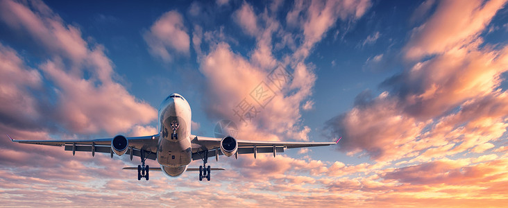 飞机天空上日落时降落五颜六色的天空上的飞机飞机的景观蓝天上飞着五彩的云乘坐客机的旅行背景商业飞机私人飞机背景