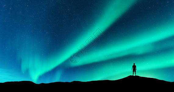 小山轮廓极光独自站山上的人的轮廓挪威洛福腾群岛北极光轻人天空中星星绿色的北极光夜间景观与北极光背景