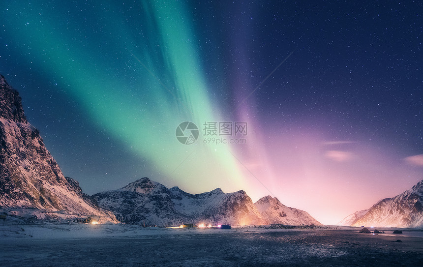 雪山上绿色紫色的北极光挪威洛福滕岛的北极光极地灯光的星空夜间冬季景观与极光,高岩石,海滩旅行风景图片