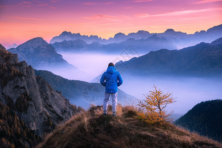 山顶上运动的人,白云岩秋天的彩色日落时,看着低云的山谷风景与旅行者,雾山,森林秋天,惊人的天空黄昏阿尔卑斯山背景图片