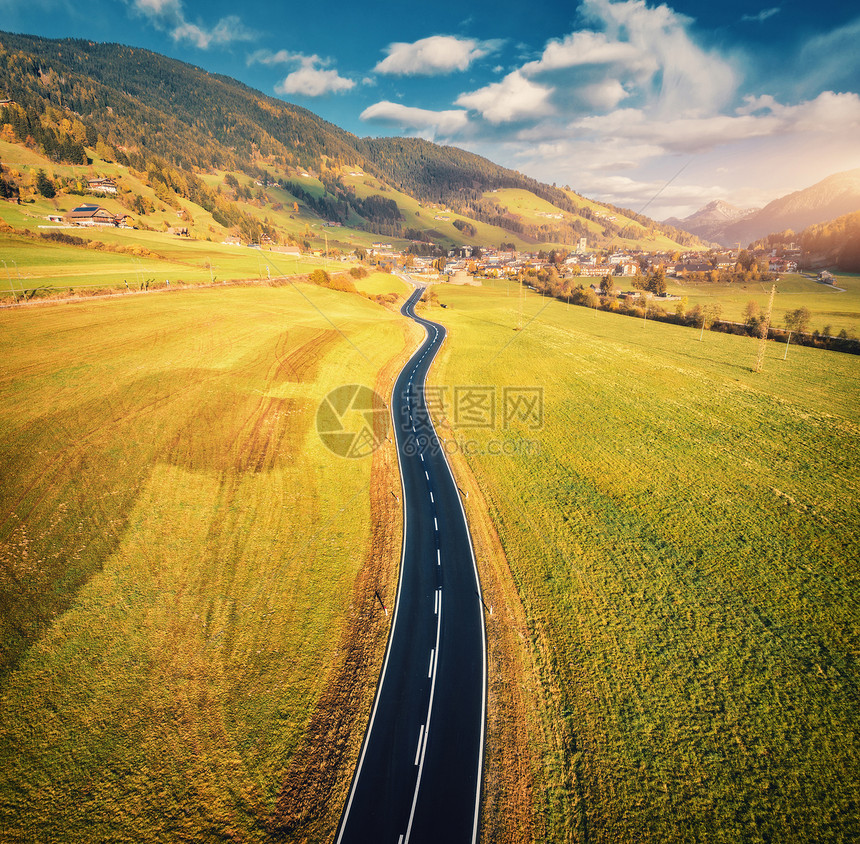 意大利白云石的山谷日落时的道路鸟瞰图完美的沥青道路的顶部景观,绿草草地,秋天的村庄公路穿过田野欧洲旅行图片