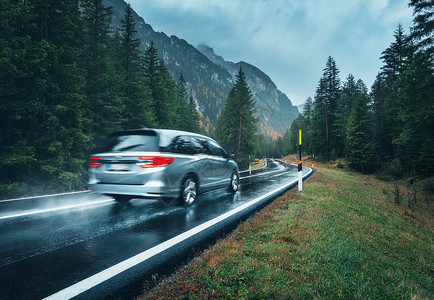 空山新雨模糊的汽车秋天的森林里的道路上运动阴雨天完美的沥青山路巷道,意大利阿尔卑斯山的松树运输雾林中的公路旅行背景