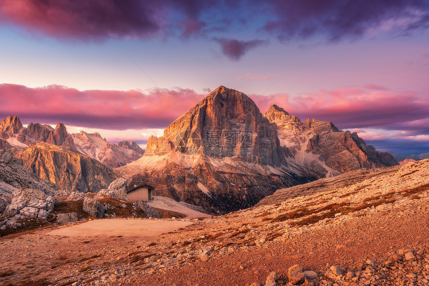 意大利白云石日落时的山脉景观与高岩石,石径,小房子,紫色的天空与粉红色的云晚上秋天的风景与山谷意大利阿尔卑斯山黄图片