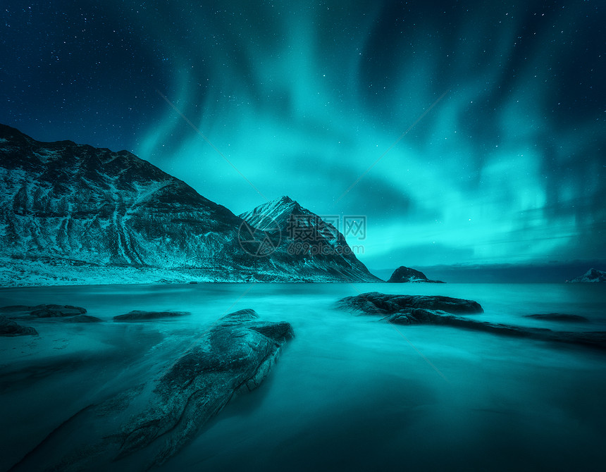 雪山沙滩上的北极光,石头挪威洛福滕岛的北极光极地灯光的星空夜间冬季景观与极光,海洋与模糊的水图片