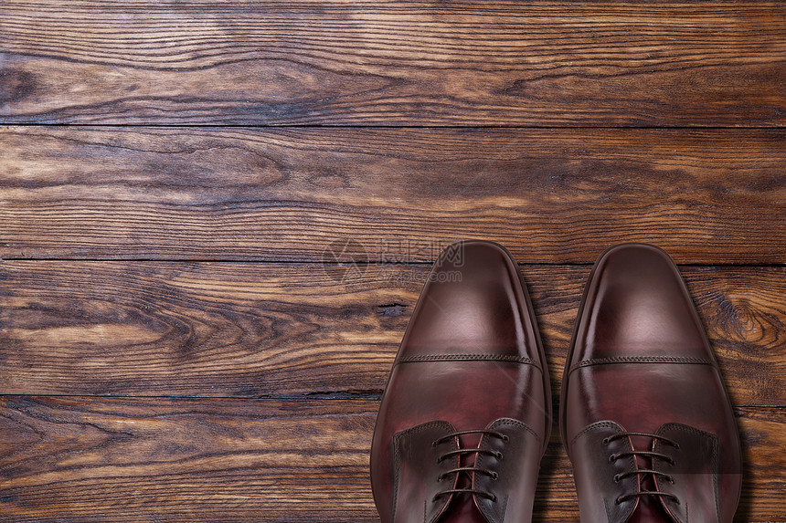 木制背景上的经典男棕色皮鞋经典的棕色皮鞋木头上图片