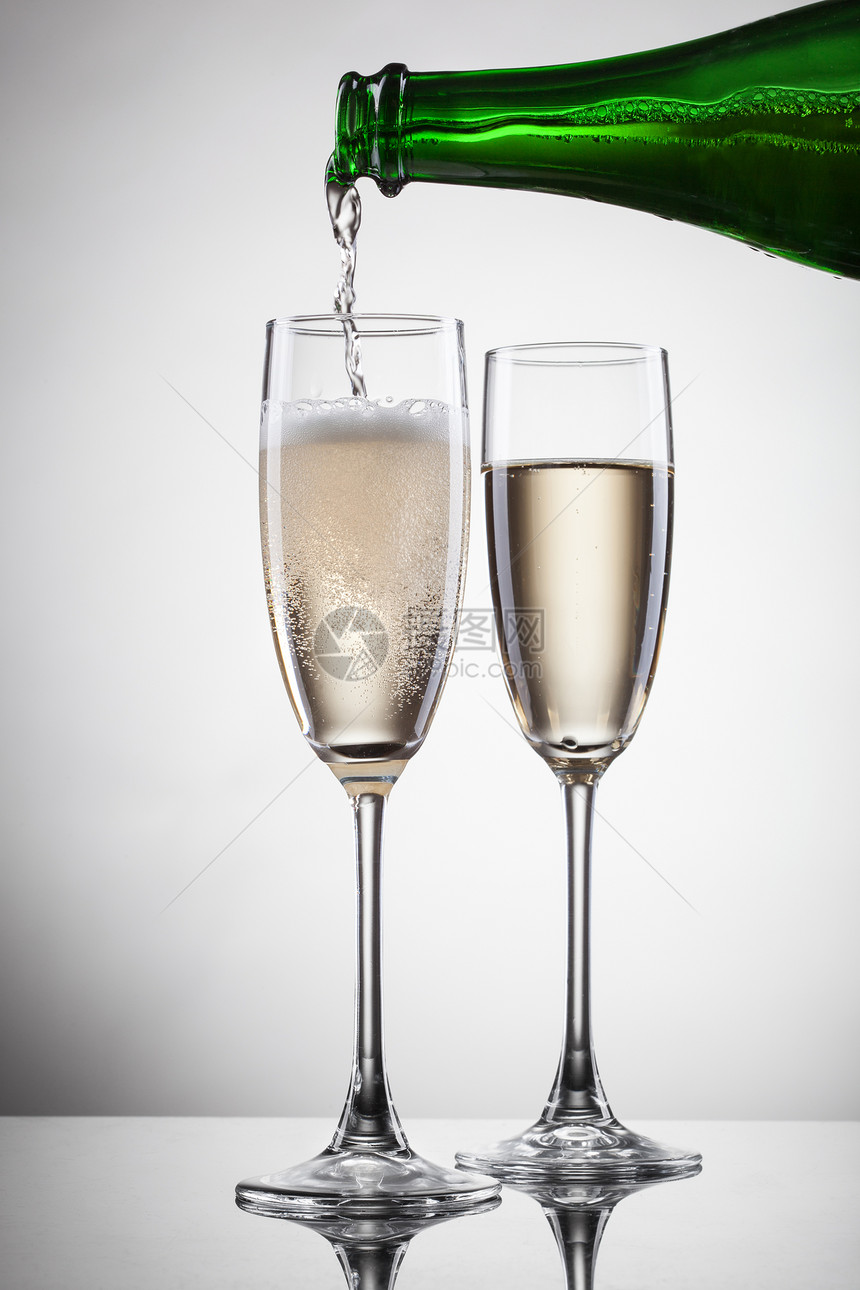 香槟倒入白色隔离的璃中图片