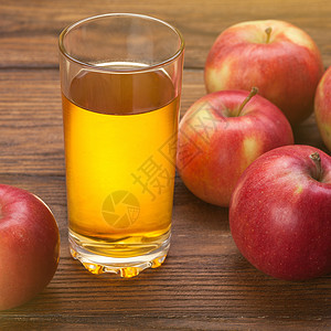 纽崔宁木制背景上的杯苹果汁红苹果背景