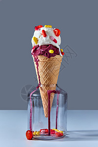 个蛋卷冰淇淋,红黄片棒棒糖,放灰色桌子上的璃瓶里夏季卡他病的及其治疗与文字的地方华夫饼锥与个冷冰淇淋站背景图片