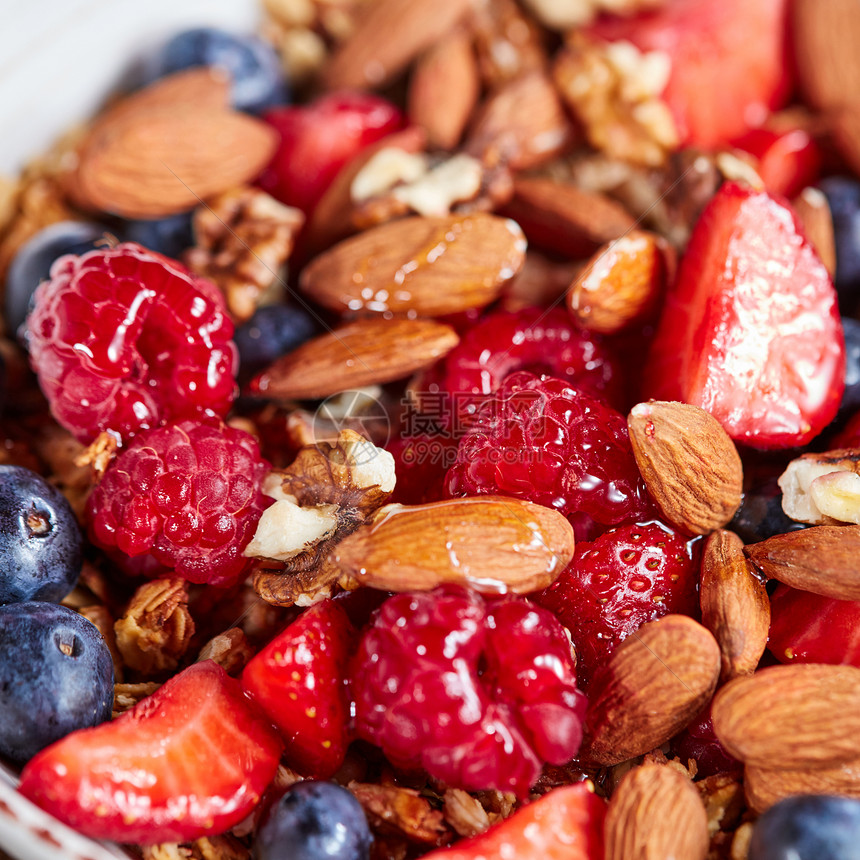 五颜六色的混合浆果,坚果,燕麦片,麦片蜂蜜特写膳食营养成分健康素食天然机覆盆子,草莓,蓝莓,燕麦亚麻蜂蜜图片