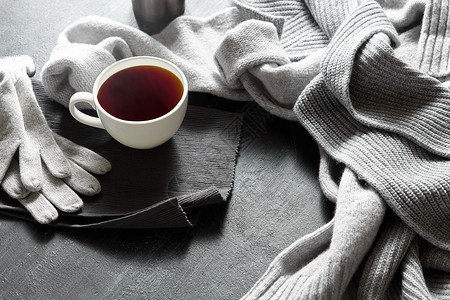 杯热咖啡张黑色桌子上,照片温暖的毛衣与杯子,冬天的早晨,顶部视图黑桌子上的杯热咖啡背景图片