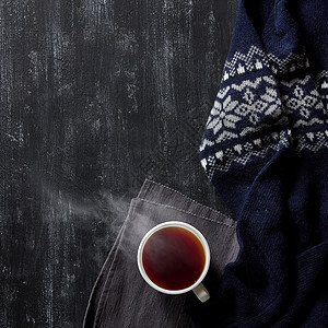 杯黑木背景的热茶,温暖的冬季毛衣,舒适的冬季家庭背景图片