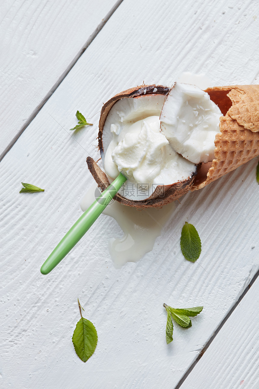 香草冰淇淋华夫饼锥与勺子椰子白色背景与薄荷叶白色木制背景华夫饼锥冰淇淋图片