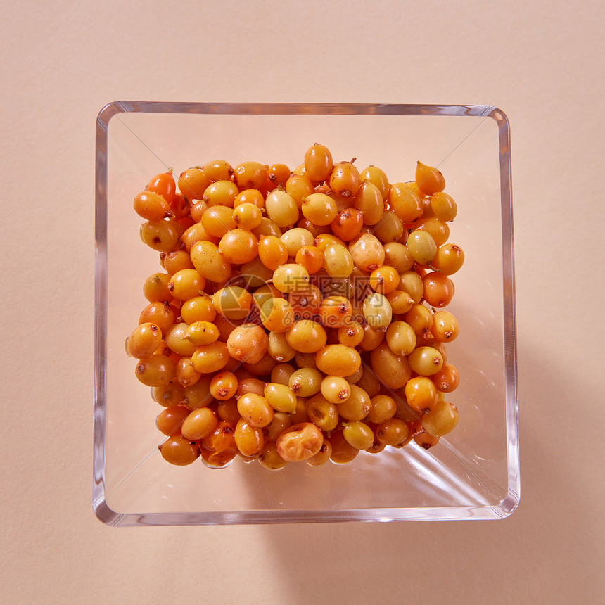 新鲜采摘的天然橙色浆果沙棘盘子上的纸张背景健康机五颜六色食物的天然机沙棘璃板黄色成熟甜浆果米色纸背景图片