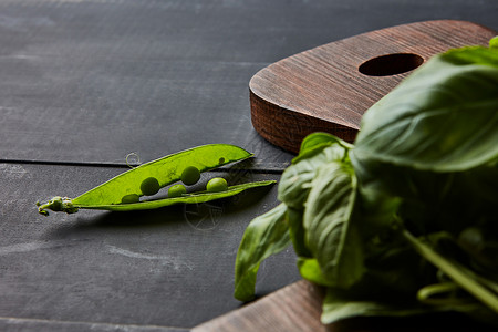 罗勒叶个旧的木板个开放的豌豆荚个木制的桌子上,个机健康食品豌豆荚罗勒叶个木板上的黑暗木制图片