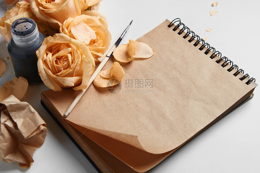 特写日记笔记本,覆盖着橙色的玫瑰它们的花供你的笔记墨水笔个很好的想法,代表你的想法情绪棕色的页日记笔记图片