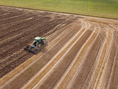 收获后田野的无人机上俯瞰拖拉机田间收割后耕田准备土壤播种工作收割后用拖拉机收割后,个无穷无尽的农田用拖拉机种背景图片
