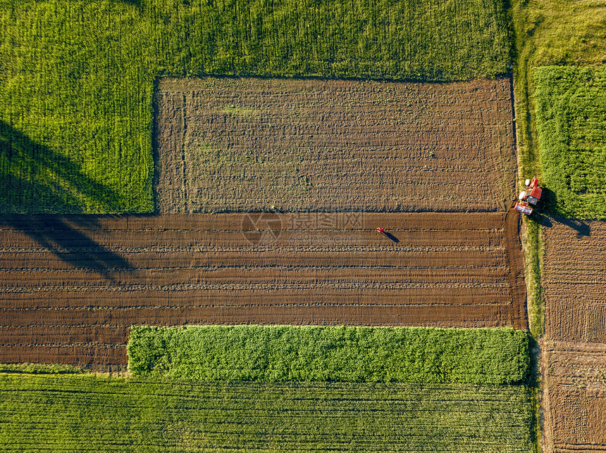 同作物土壤的抽象几何形式的农田,没作物播种,用道路拖拉机隔开,绿色黑色,树上阴影无人机上鸟瞰无人图片