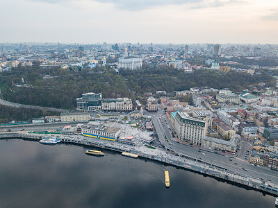 空中全景无人机中央历史部分的城市Kiyv,波多尔区与邮政广场,酒店,教堂,河港日落多云天空聂伯河的反射全景鸟瞰背景图片