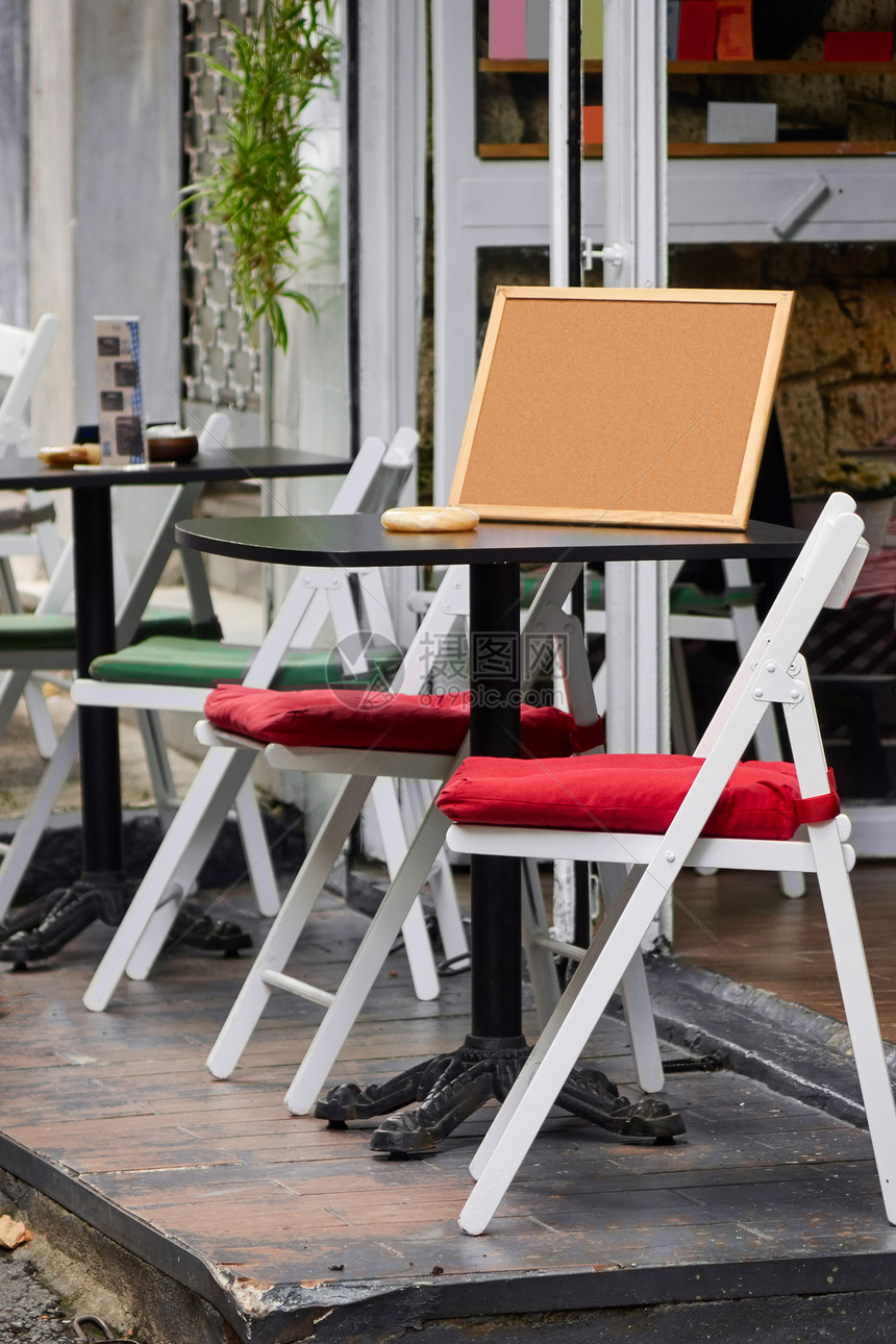 街道咖啡馆与白色木制椅子,红色绿色枕头黑色桌子伊斯坦布尔伊斯坦布尔大街上舒适的咖啡馆,没人图片