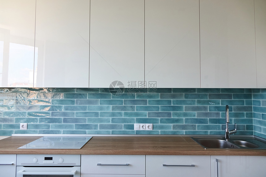 厨房里的棕色台,水槽,蓝色瓷砖,内部背景个漂亮的新厨房内部图片