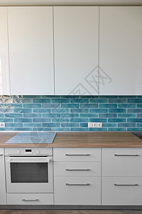 厨房的部分,滚刀,烤箱棕色顶部的白色蓝调厨房现代风格的厨房用具图片