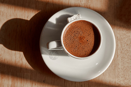 杯土耳其咖啡,泡沫隔离张木制的棕色桌子上杯带泡沫的土耳其咖啡图片