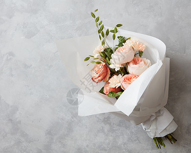 美丽的粉红色玫瑰花与白纸灰色的石头背景美丽的粉红色玫瑰图片