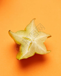成熟的星果杨桃橙色背景的星苹果,健康的水果食品黄色水果杨桃分离橙色背景图片