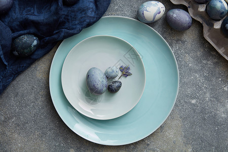 盘子画用蓝色布盘子上画鸡蛋的快乐复活节用蓝布烤复活节彩蛋背景
