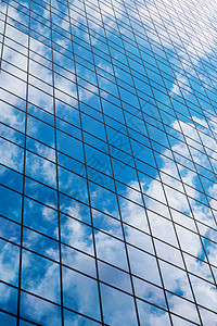 现代烟熏璃办公楼映衬着蔚蓝的多云的天空天空中的办公室图片