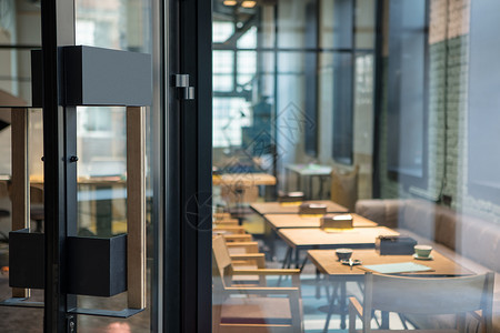 餐厅大门咖啡厅前木制璃门上的现代门把手现代风格的室内门开餐厅咖啡馆前木制璃门上的现代门把手背景