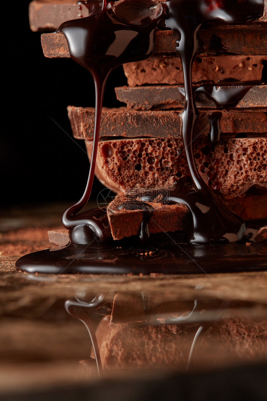 巧克力糖浆滴堆叠的黑巧克力上堆碎块巧克力图片