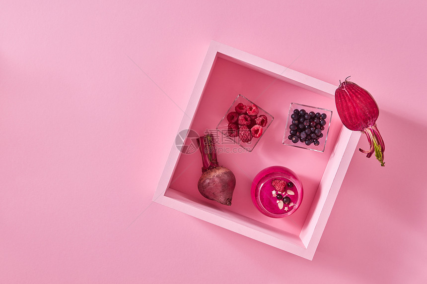 甜菜根浆果冰沙璃杯里食物成与个木制框架与杯冰沙,个盘子与覆盆子醋栗粉红色的纸背景与的风景图片