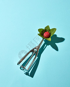 创意构图荔枝水果与薄荷叶金属勺子冰淇淋蓝色璃背景图片
