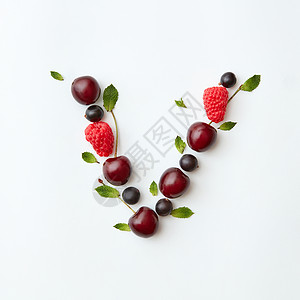 v字领字母v英文字母以自然机浆果的形式出现成熟的新鲜树莓黑色醋栗樱桃绿色薄荷叶白色背景上分离顶部视图浆果机模式的字背景