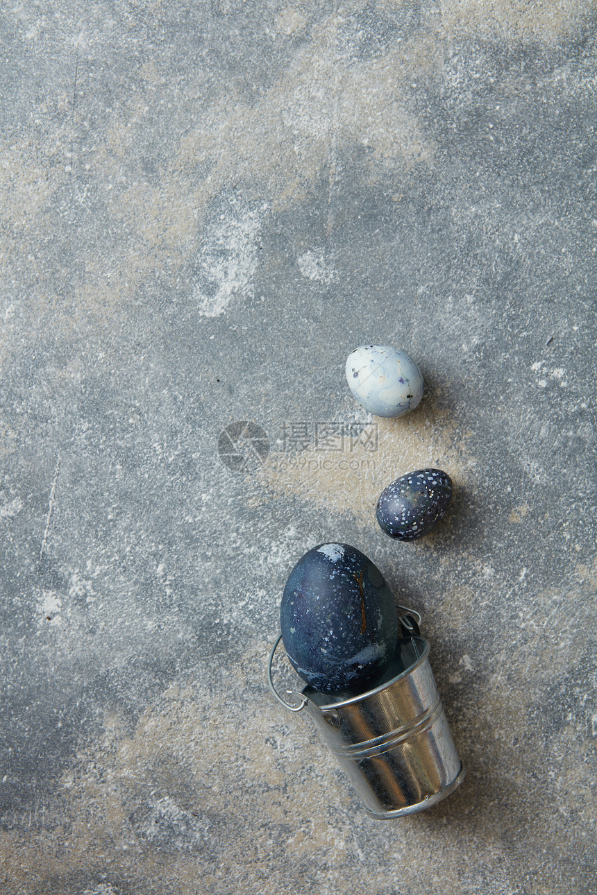 石头背景上蓝色鸡蛋的金属桶带鸡蛋的桶图片