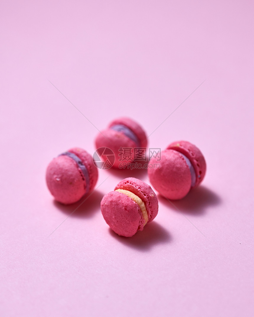 顶部的迷你粉红色马卡龙软甜粉红纸背景与为您的文本糖果食物背景粉红色迷你马卡龙粉红色的纸背景与图片