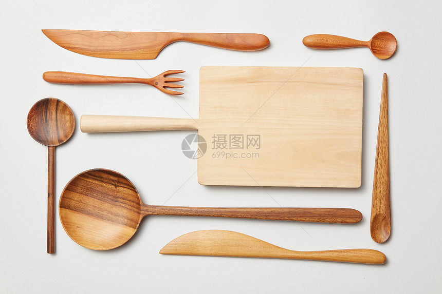 白色背景上的木制厨房用具切割板,叉子,刀勺子白色木制背景上的各种厨房用具图片