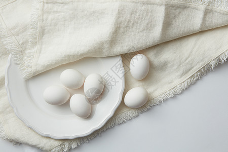 白盘布上的鸡蛋白盘上的生鸡蛋图片