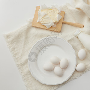 生鸡蛋,牛奶,黄油,粉勺子的顶部视图烹饪的原料烘焙配料炊具图片