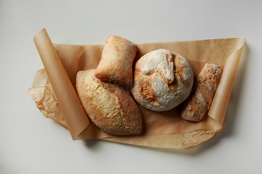 同种类的黑麦包代表烘焙纸上分离的白色背景各种各样的新鲜包背景上同种类的包图片
