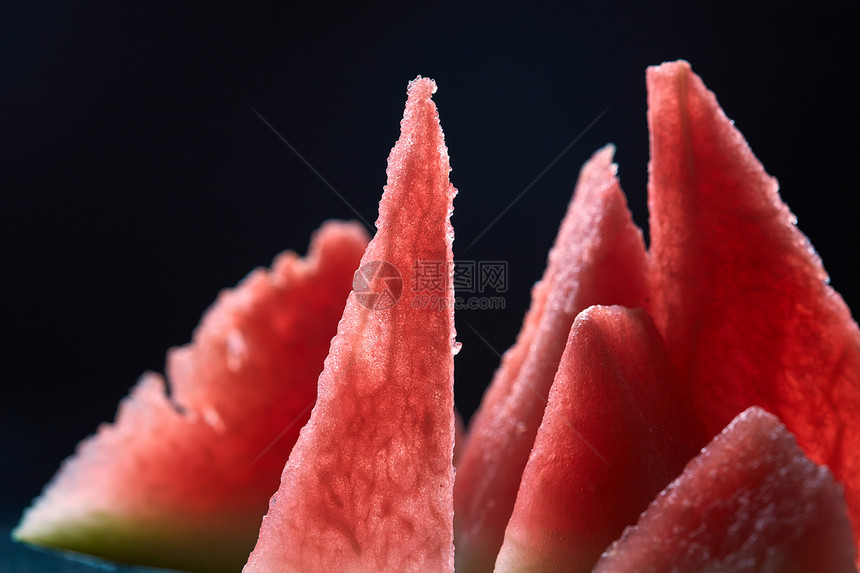 三角形形状的西瓜片黑暗的肮脏背景上俯视图成熟多汁的西瓜片图片