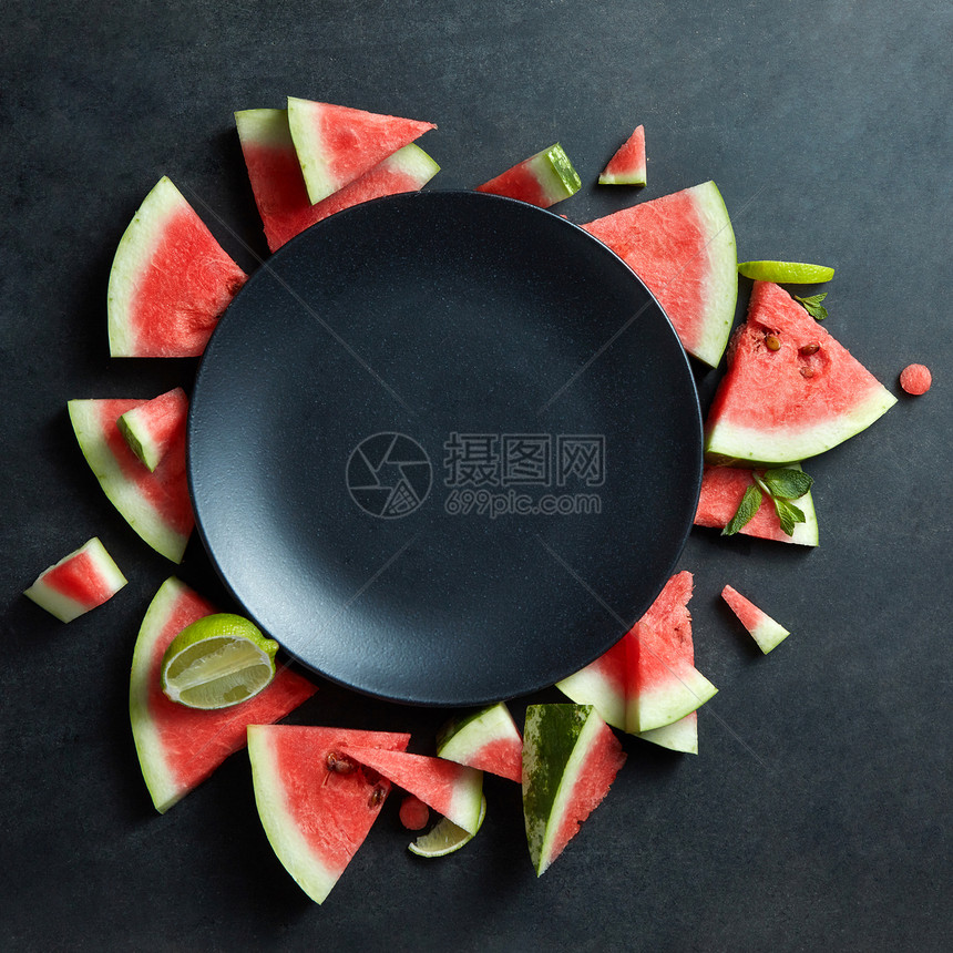 西瓜片放个黑色的盘子里文本的西瓜片放黑色盘子上的圆圈里图片
