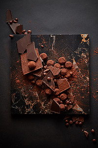 黑巧克力松露洒深色大理石盘子上的可可粉中各种黑巧克力松露图片