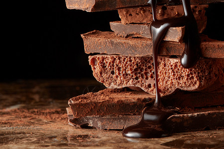 巧克力糖浆滴堆叠的黑巧克力上堆碎块巧克力图片